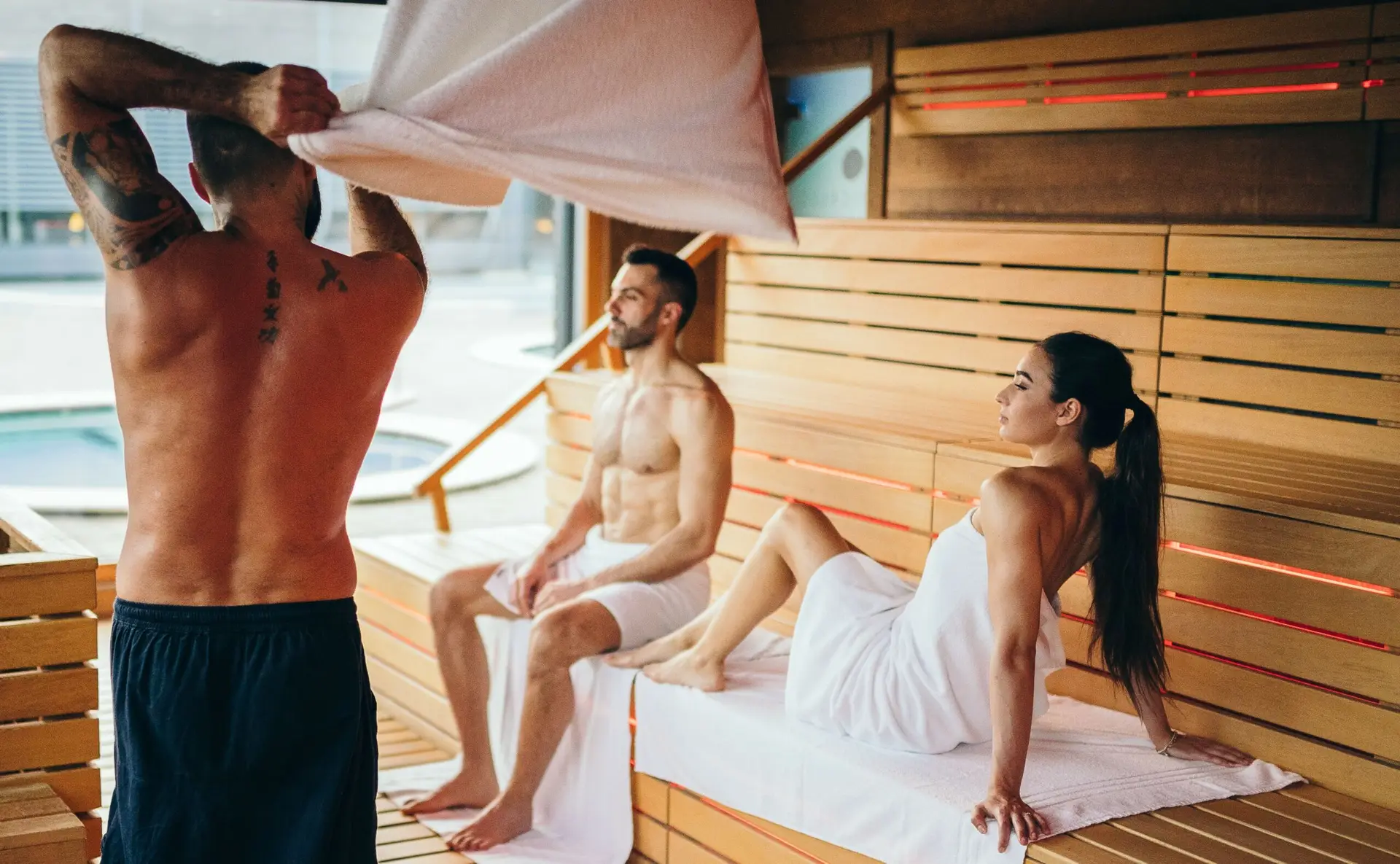 Tre persone si rilassano in una sauna dopo la riapertura.