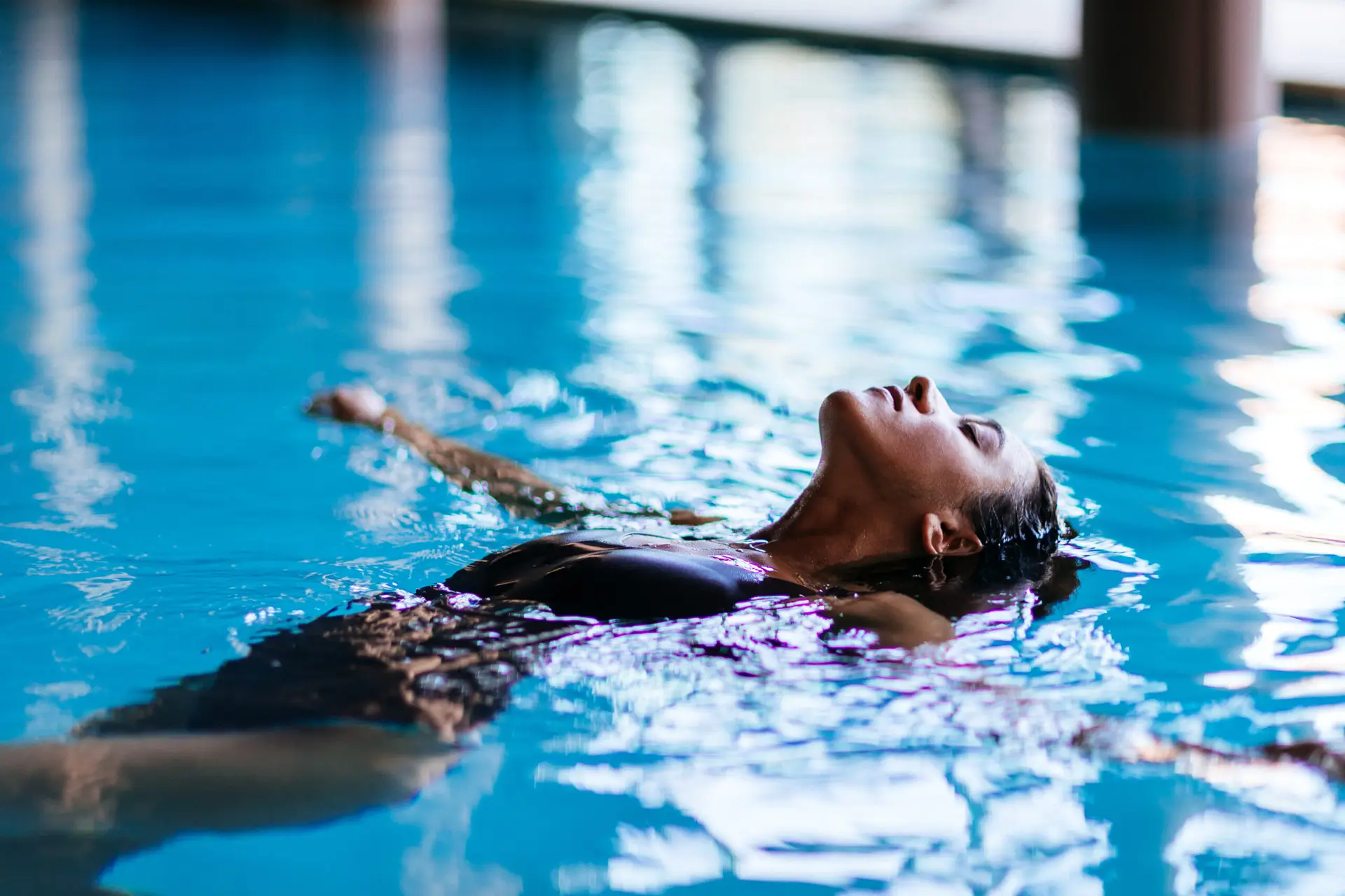 Donna che si rilassa in piscina, godendosi la riapertura.