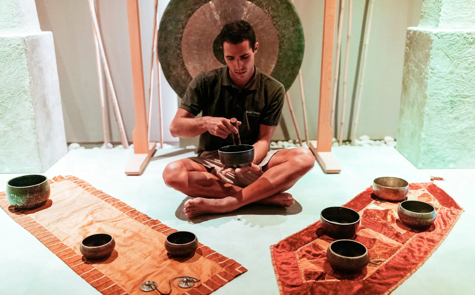 Un uomo suona le campane tibetane durante un bagno sonoro, a simboleggiare la riapertura.