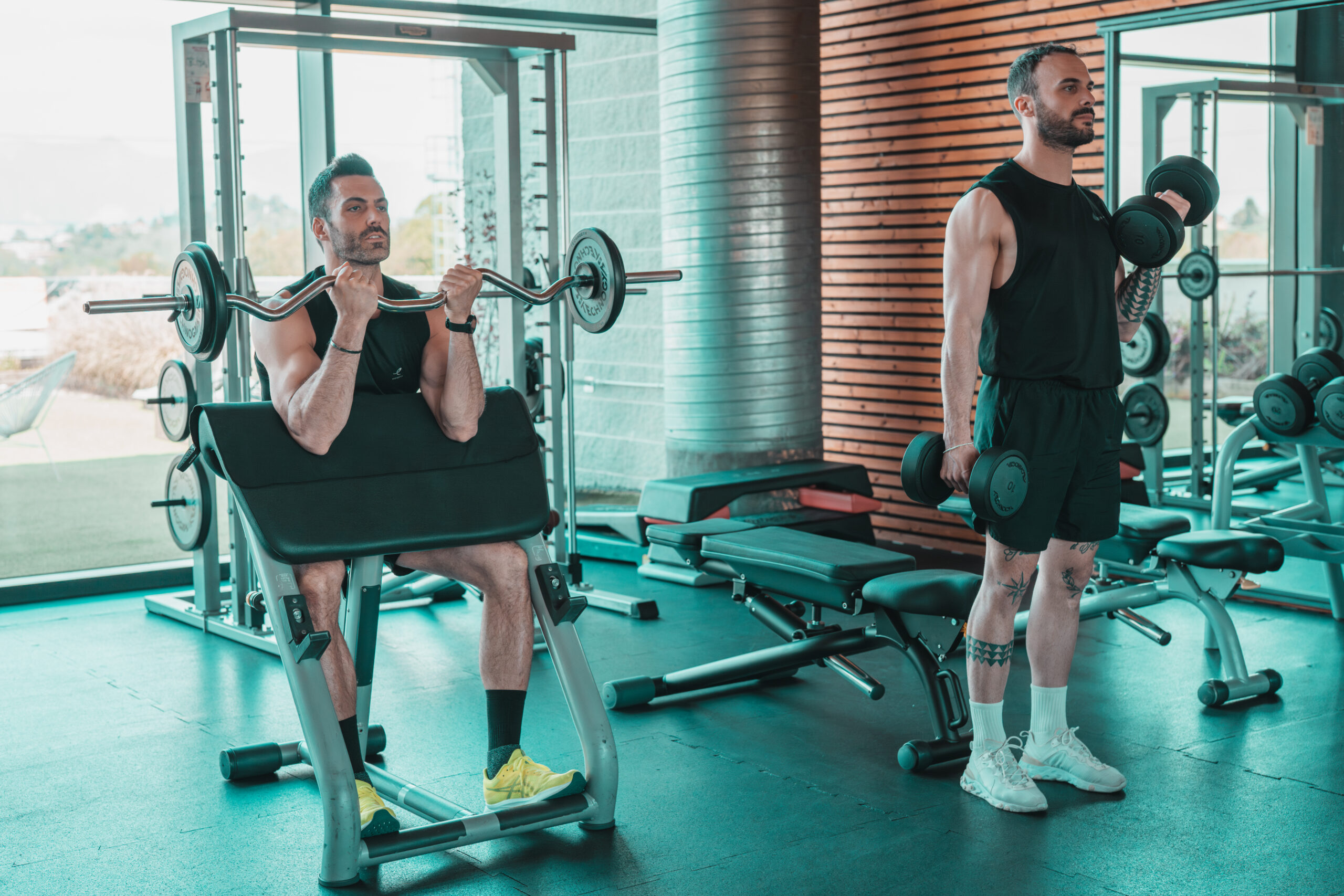 Due uomini che sollevano pesi in una palestra moderna