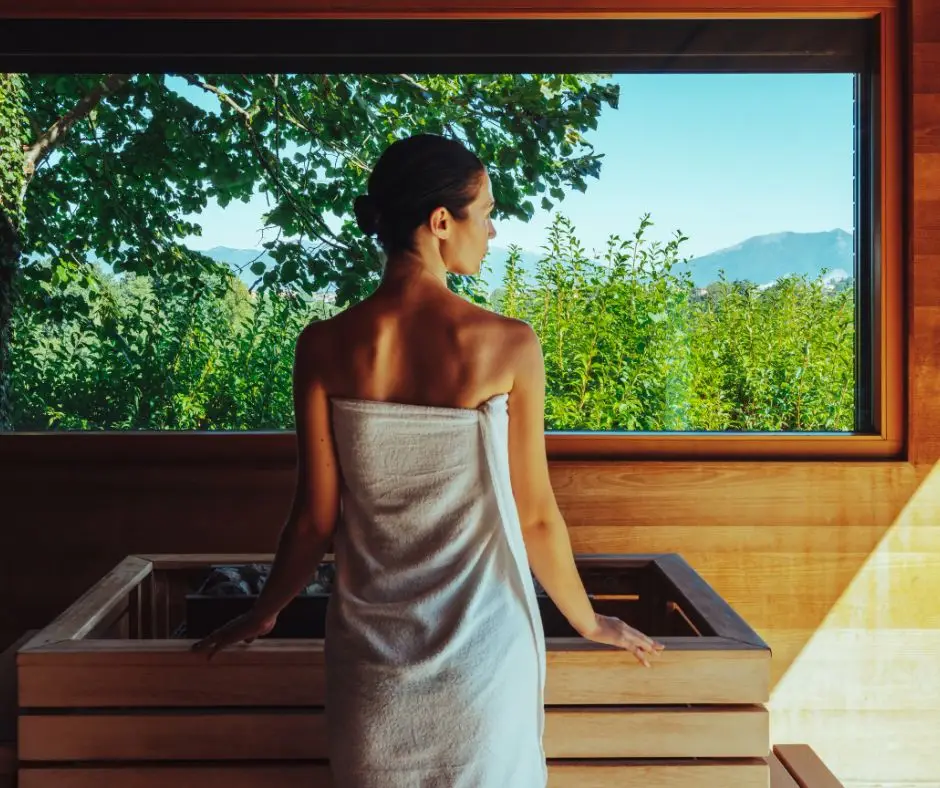 Donna rilassata al Monticello Spa, avvolta in un asciugamano, guarda il panorama.