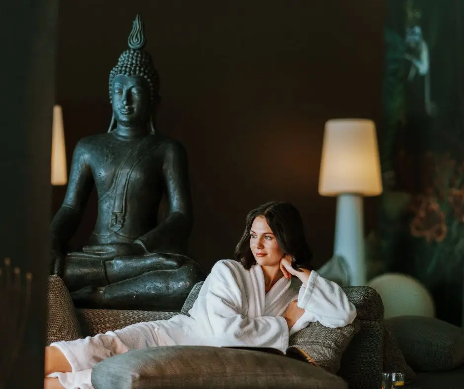 Donna rilassata in accappatoio al Monticello Spa, con statua di Buddha.