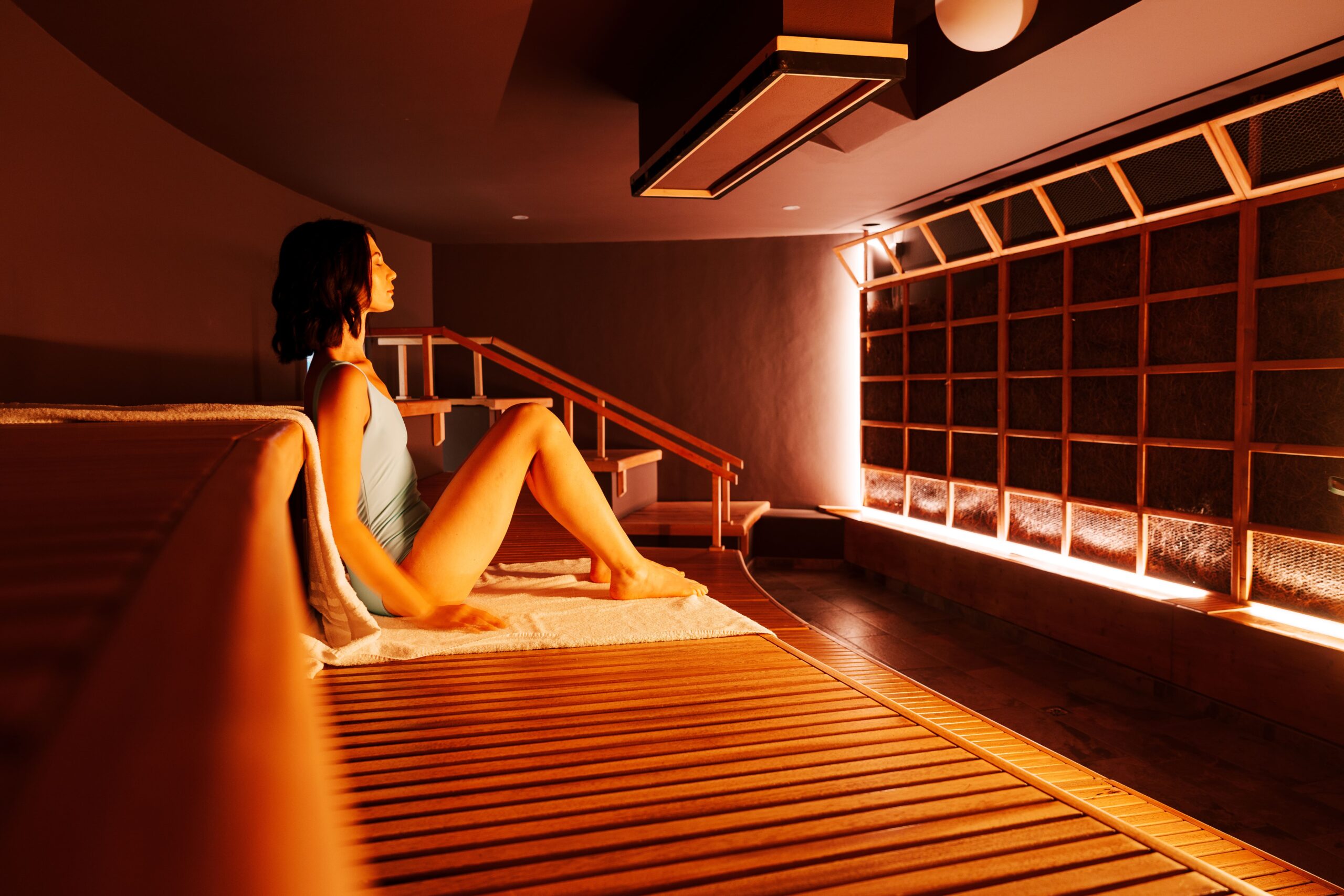 Person relaxing in a sauna, enjoying wellness and relaxation.