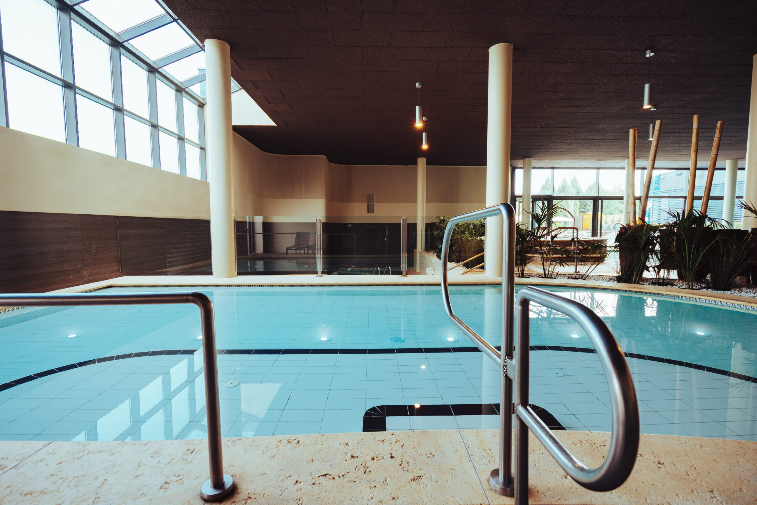 Piscina interna con acqua azzurra e mosaico, ideale per un percorso benessere rilassante.