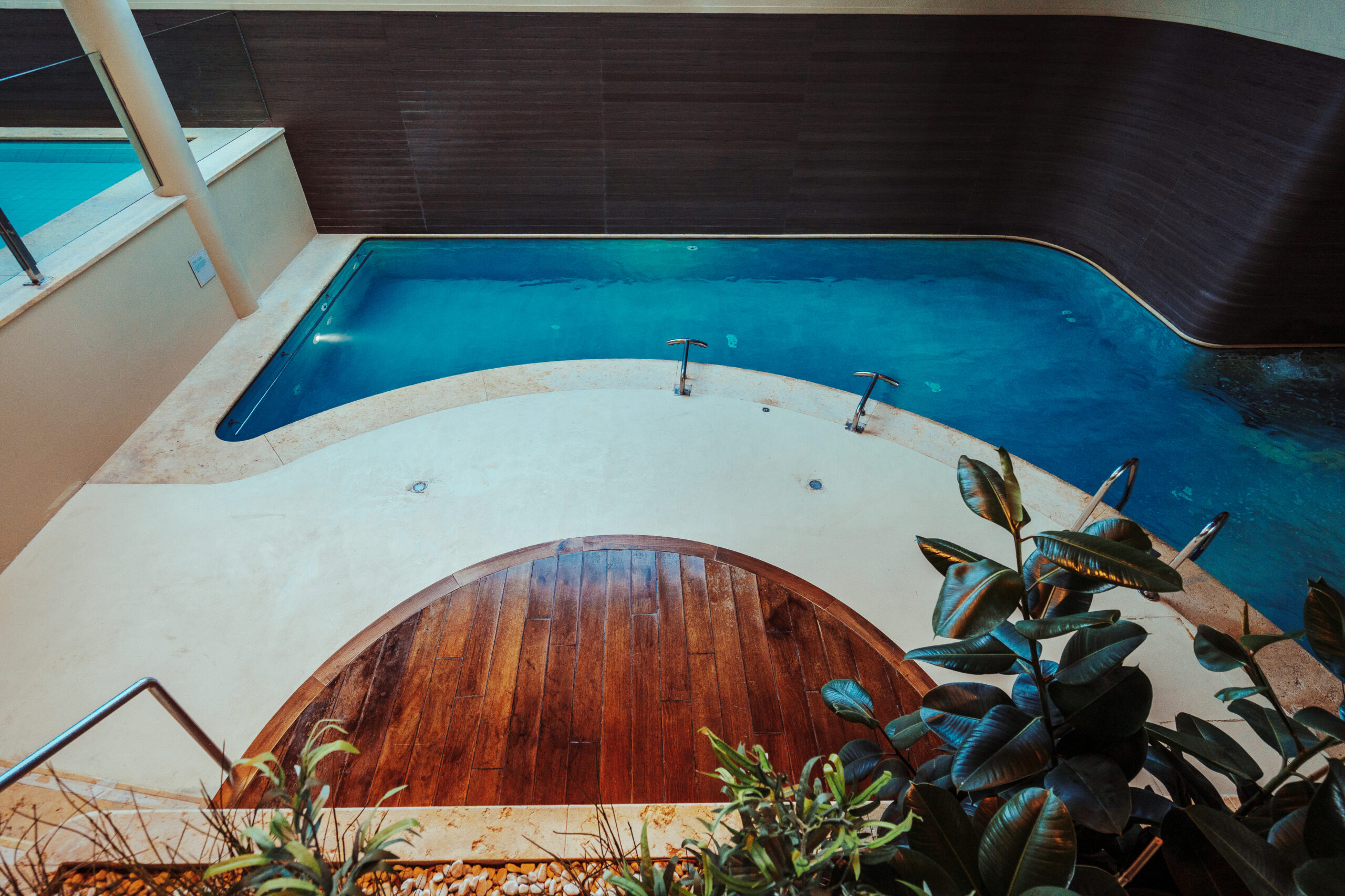 Piscina interna con area benessere e dettagli in legno. Percorso Benessere.